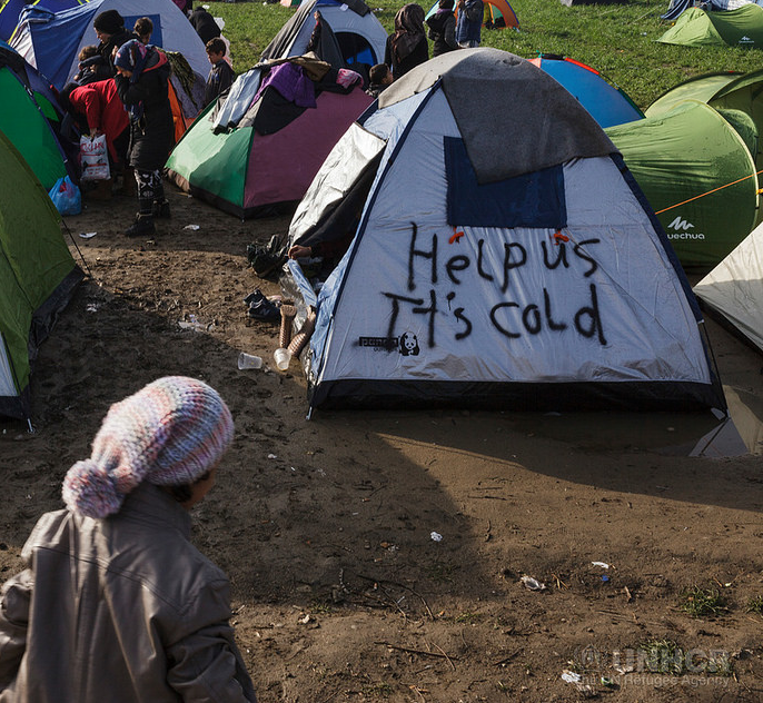 "Open the borders" and "Help us it's cold" written across tents in refugee camps as a cold winter with insufficient heating provision approaches